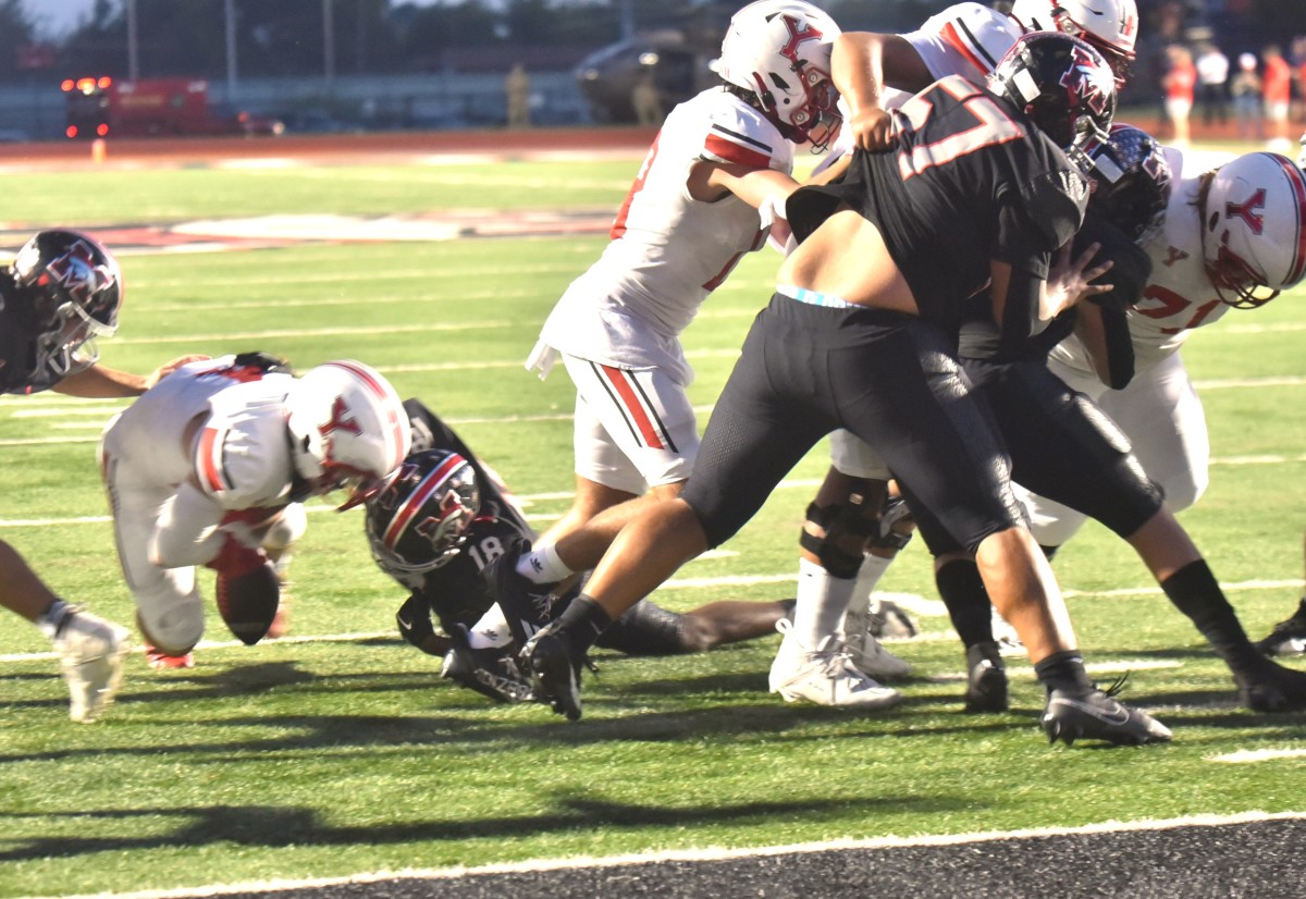 Mustang safety Zach Warren (next to right) helps make a stop on fourth-and-goal during the Broncos' win against Yukon on Sept. 22, 2023.